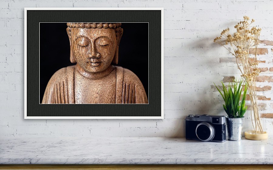 Wall art photography of the Buddha with dark mount and white frame.
