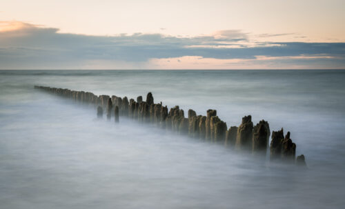 Long exposure photography of a wooden poles in the Baltic sea in Poland.